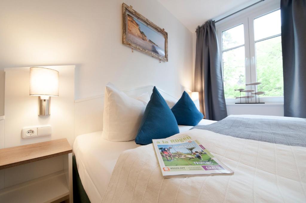 a hotel room with a bed with a book on it at Inselquartett - Appartements inkl Wäschepaket - nähe AOK-Klinik in Wiek auf Rügen