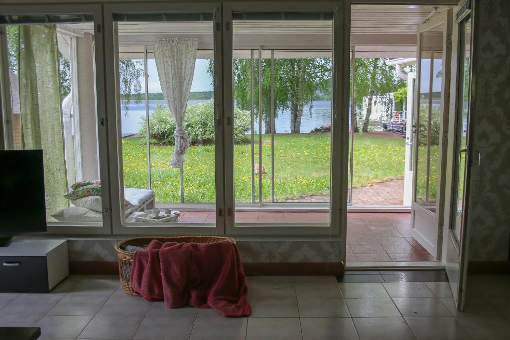 a room with large glass doors with a view of a yard at Lake Suite in Lahti