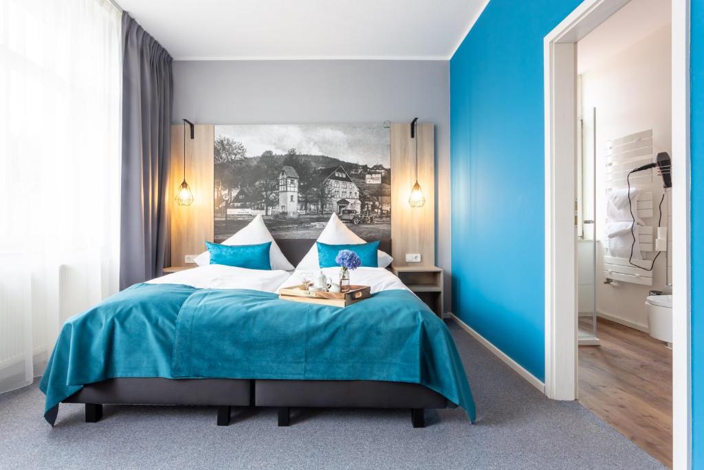 1 dormitorio azul con 1 cama y una pintura en la pared en Villa Sachsenhof en Bad Schlema