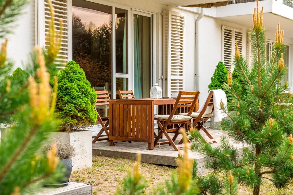 a porch with a wooden table and chairs at Kopu Vetrunges - Nida Apartments in Nida