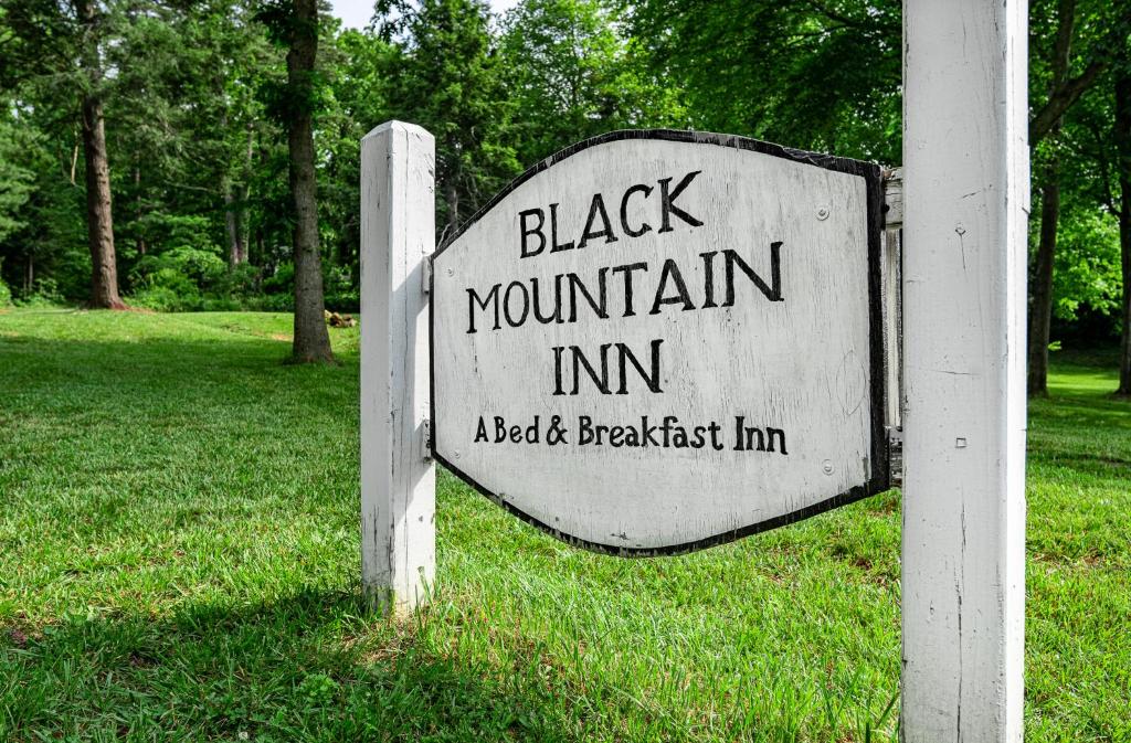 een zwart bergherbergbord op een witte paal bij Black Mountain Inn in Black Mountain