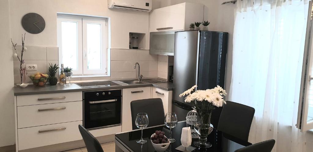 y cocina con mesa, sillas y nevera. en Apartments Karlo, en Makarska