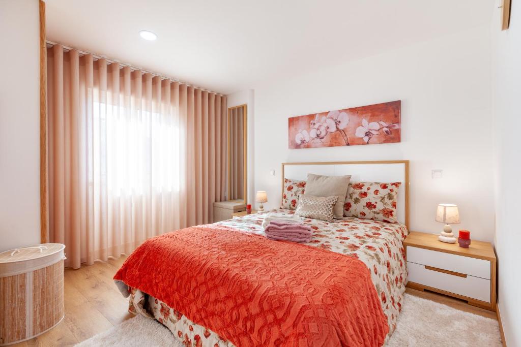 ein Schlafzimmer mit einem großen Bett mit einer roten Decke in der Unterkunft Avenida apartment 1,2 e 3 in Braga