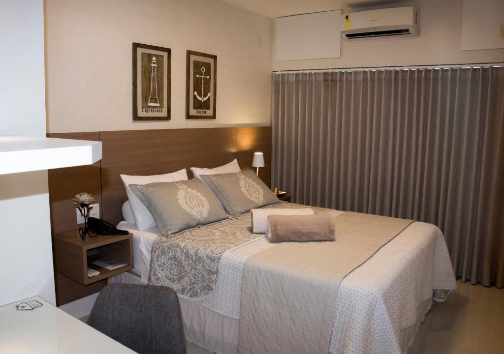 1 dormitorio con 1 cama grande con colcha blanca en Ondina Apart Hotel - Apto. 537, en Salvador