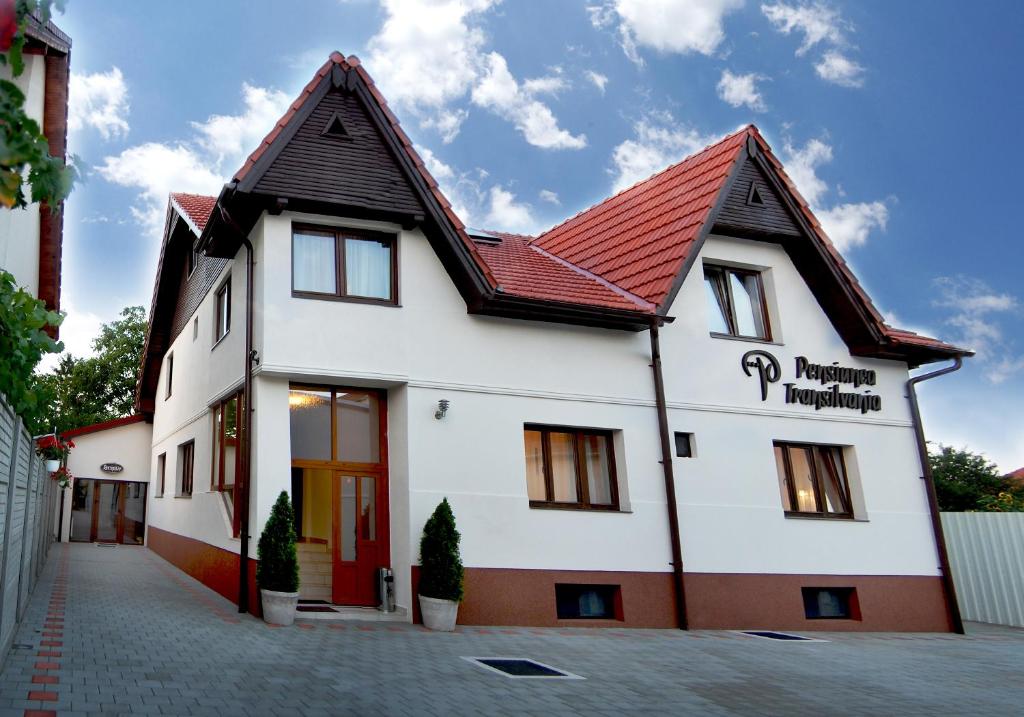 a white building with a red roof at Pensiunea Transilvania in Sibiu