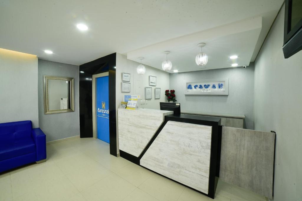 a waiting room with a counter and a blue door at Hotel Arawak Upar in Valledupar