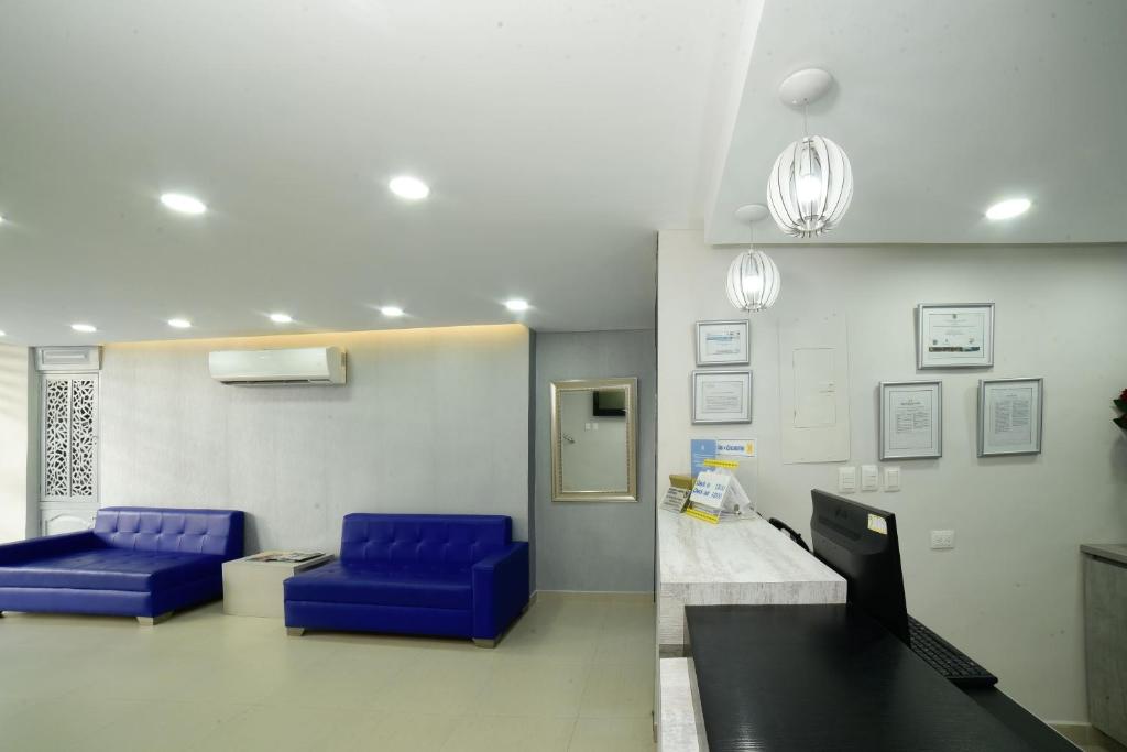 a waiting room with blue chairs in a waiting room at Hotel Arawak Upar in Valledupar