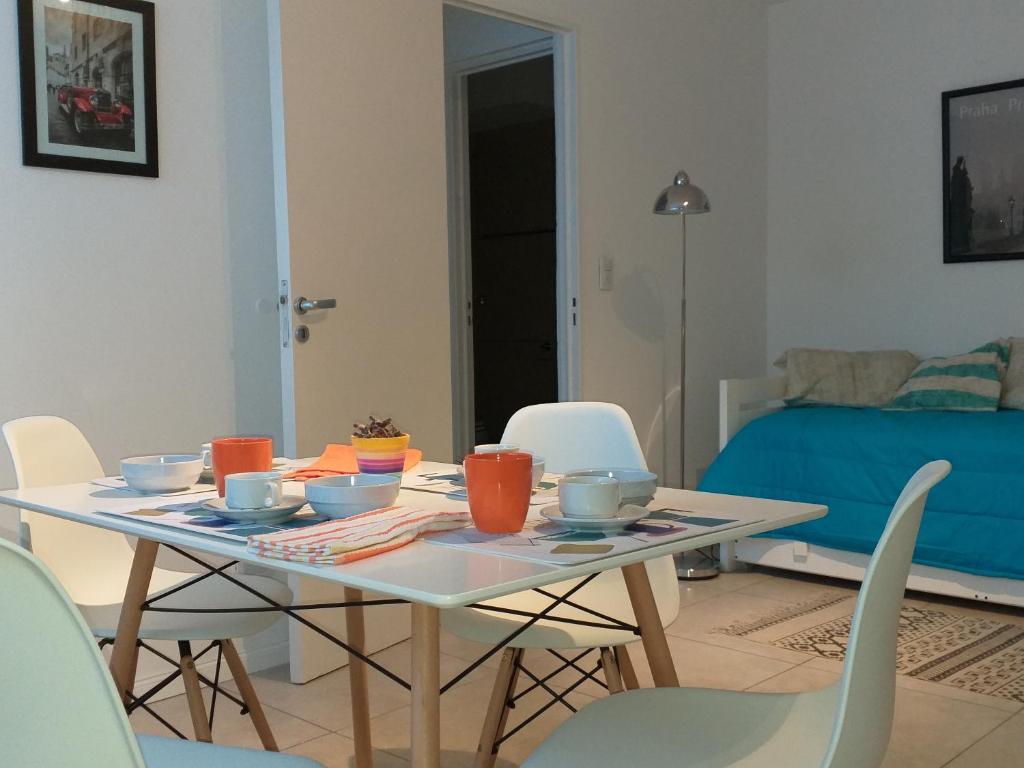 een eettafel met stoelen en een tafel met eten erop bij Apartamento Benegas in Mendoza
