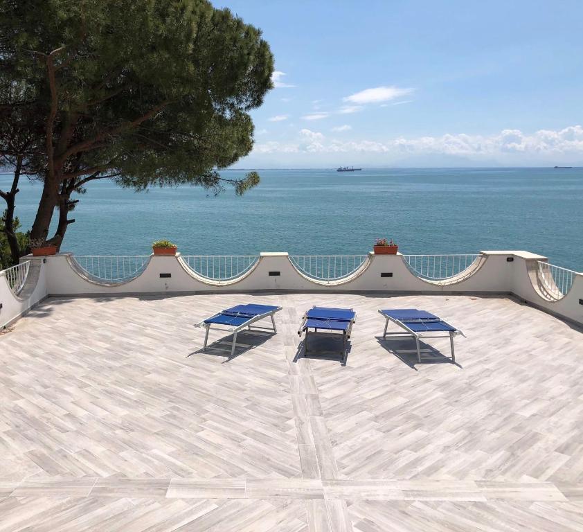 two blue chairs sitting on a patio overlooking the ocean at Amalfi Coast Luxury House in Vietri sul Mare