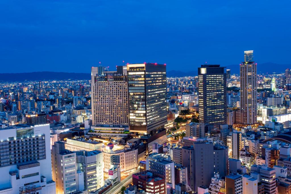 a city skyline at night with many tall buildings at Hotel Monterey Grasmere Osaka in Osaka