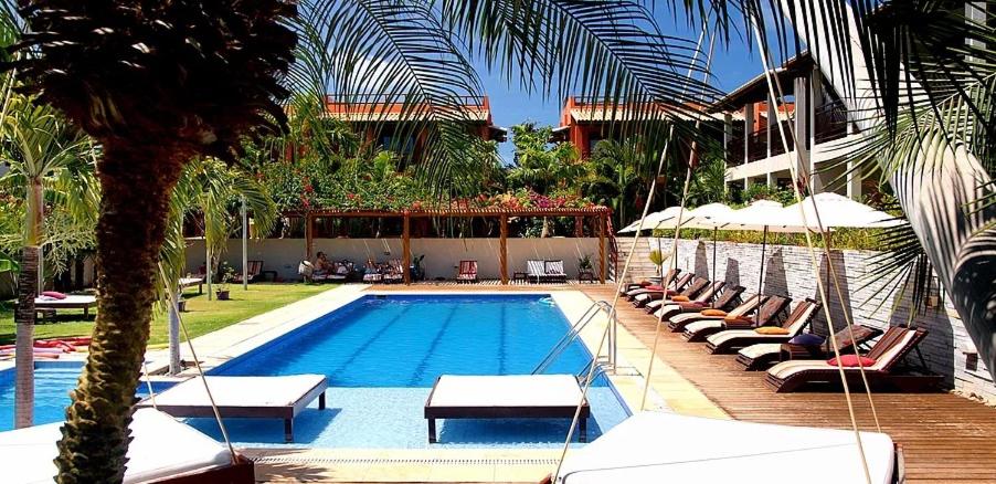una piscina con tumbonas y un complejo en Apto Pipa Beleza Spa Resort, en Pipa