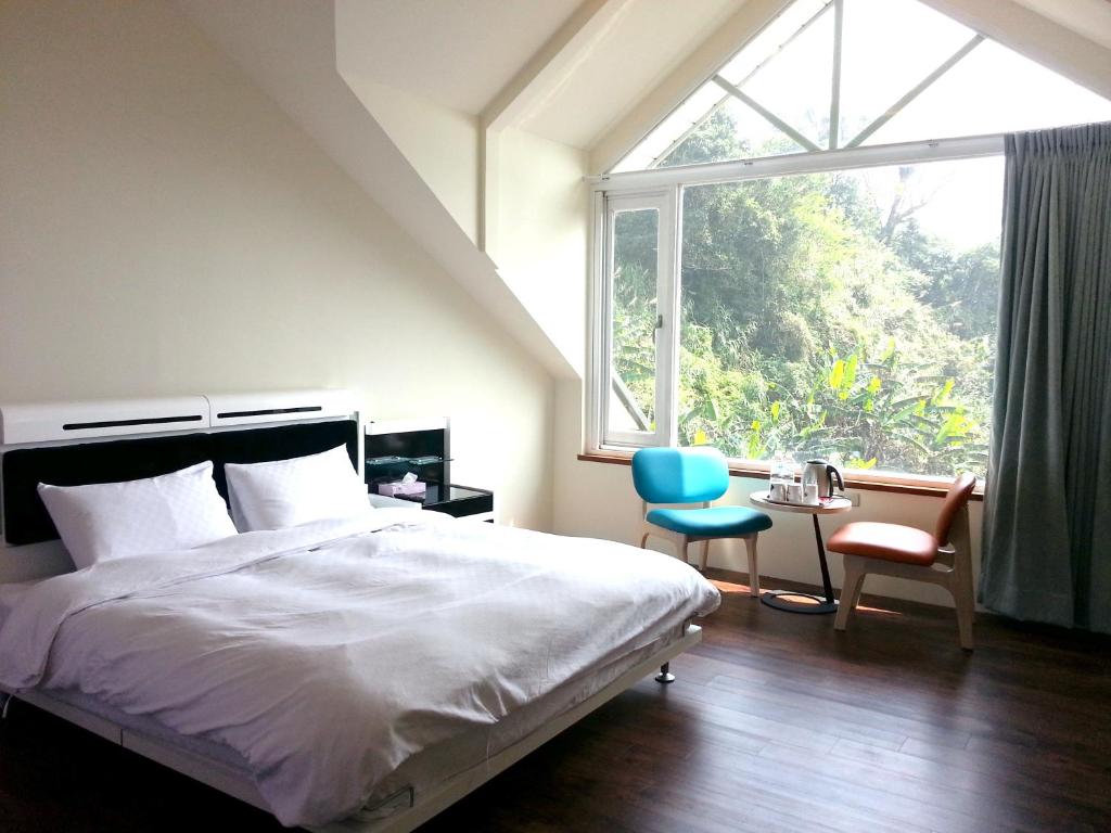 FanluにあるYun Waterfall Valley Homestayのベッドルーム1室(ベッド1台、窓、椅子付)
