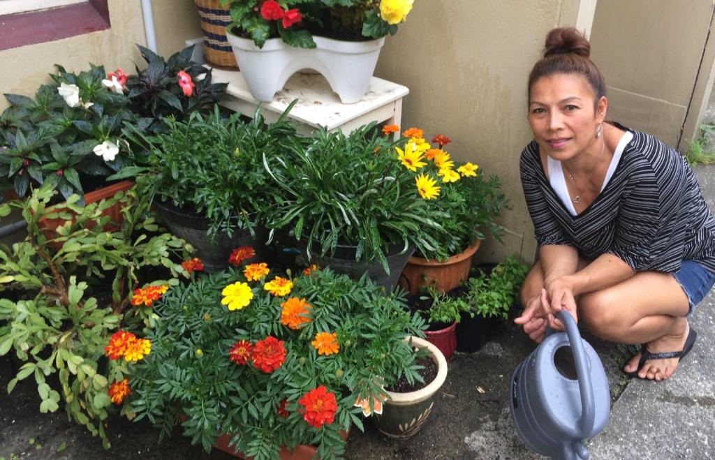 Une femme s'agenouille à côté d'un bouquet de fleurs dans l'établissement rooms with a view, à Haywards