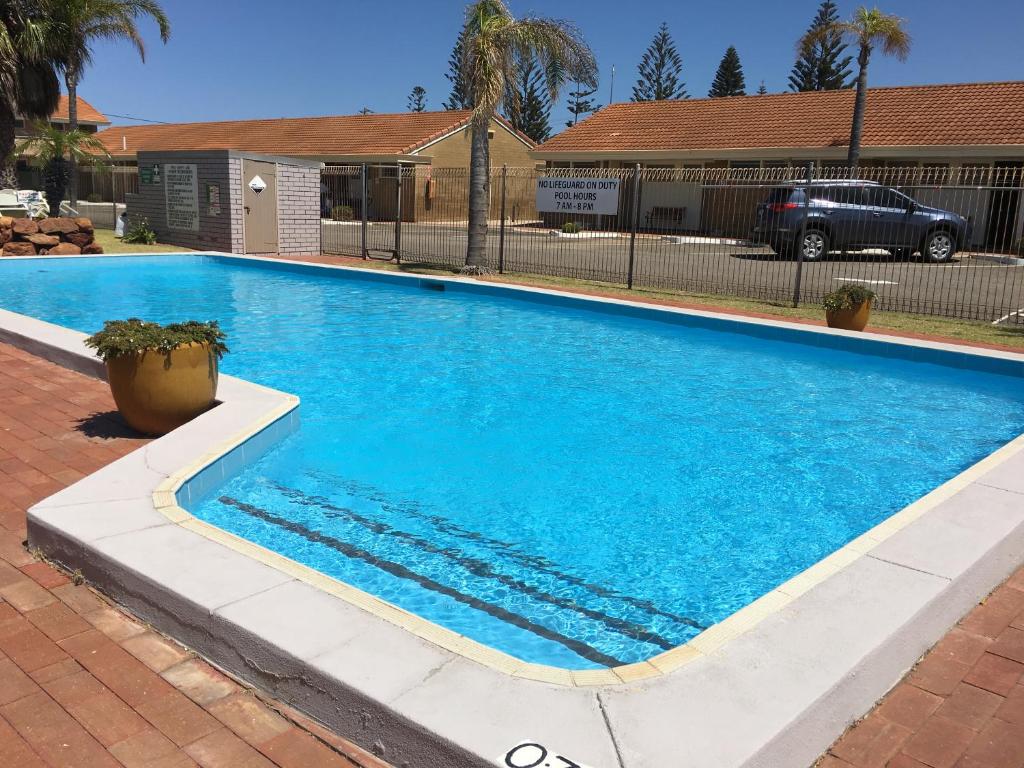 a swimming pool with blue water in a yard at Hospitality Geraldton SureStay Collection by Best Western in Geraldton