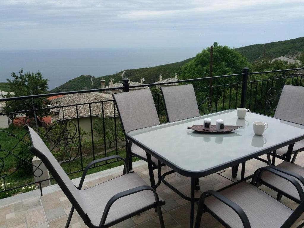 uma mesa e cadeiras numa varanda com vista para o oceano em Elenis Vista Mare em Kalamaki