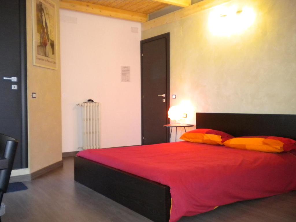 sypialnia z łóżkiem z czerwoną pościelą i pomarańczowymi poduszkami w obiekcie Trionfale Rooms w Rzymie