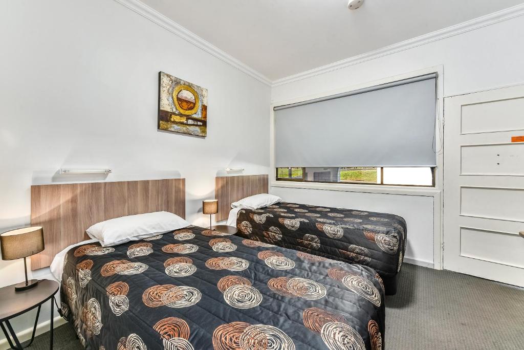 ein Hotelzimmer mit 2 Betten und einem Fenster in der Unterkunft Rest Motels in Naracoorte