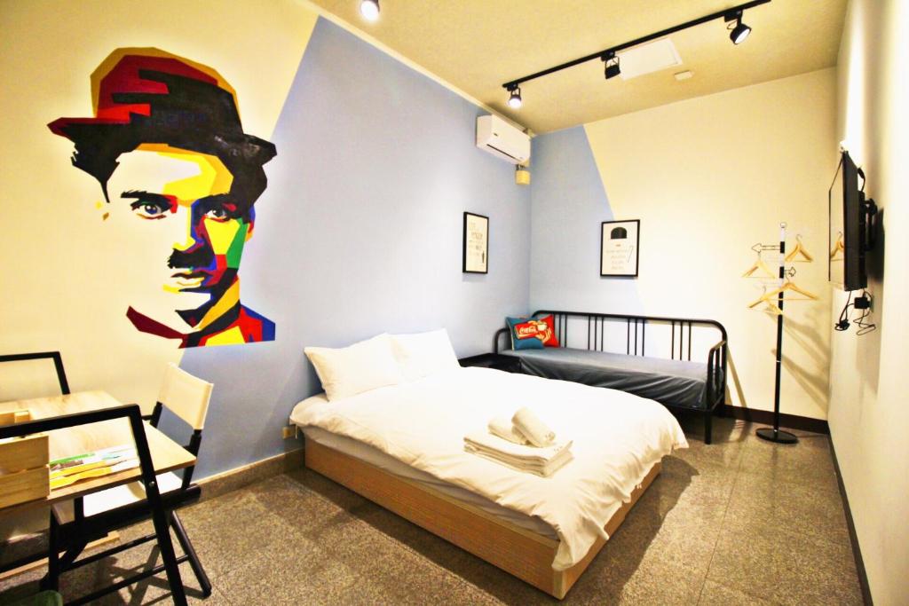 um quarto com uma cama com um quadro na parede em 逢甲旅人Inn em Taichung