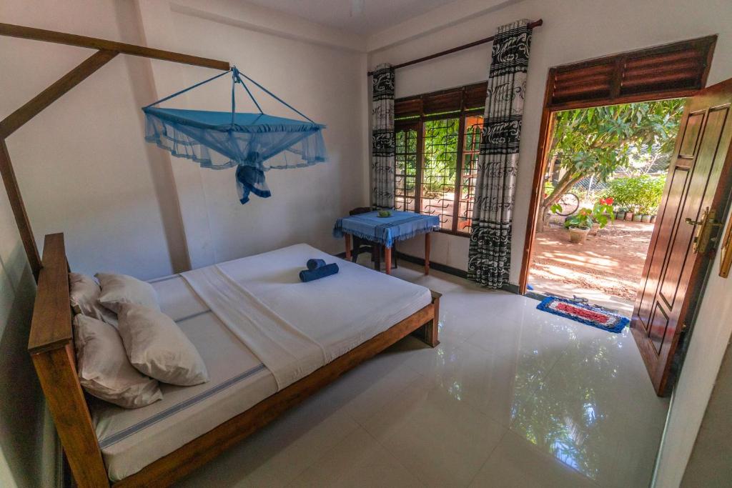 a bedroom with a bed with two shoes on it at Mango Shade Weligama in Weligama