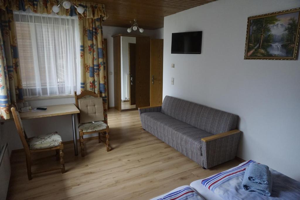 a living room with a couch and a desk at Pension-Ferienwohnung Rotar in Faak am See