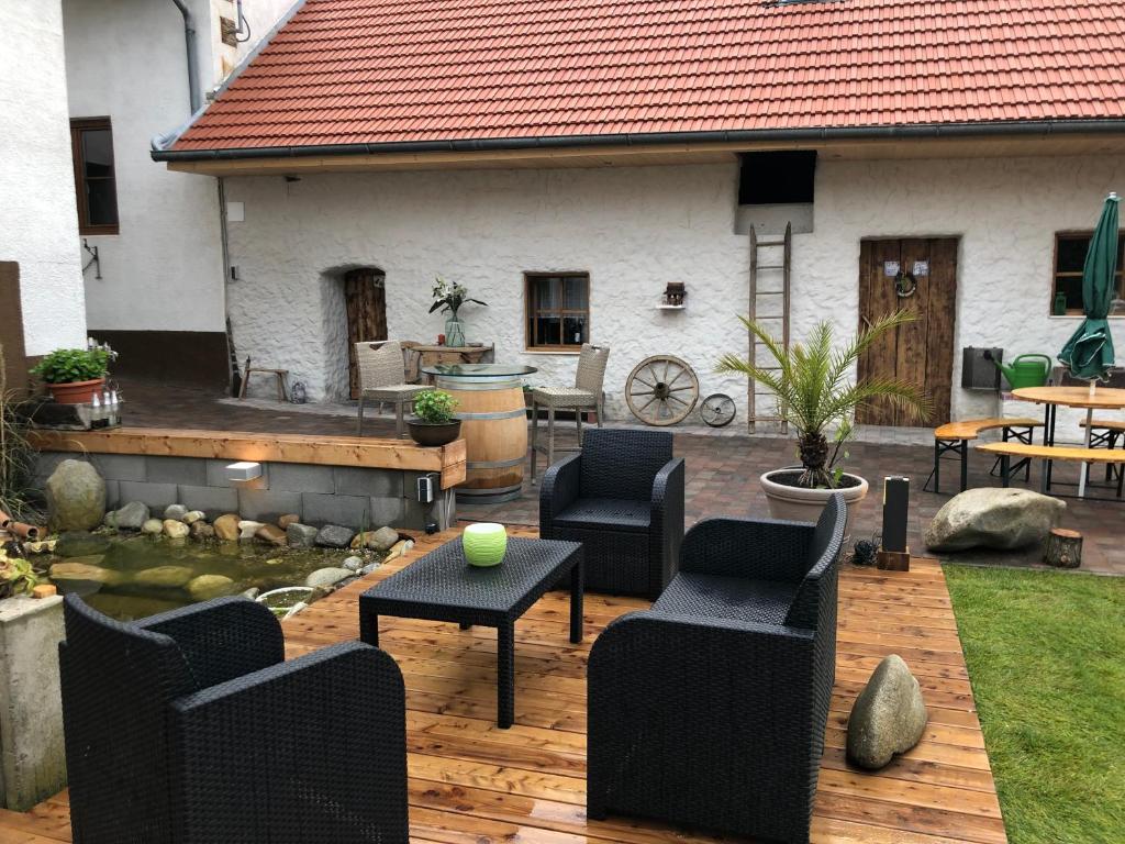 a patio with chairs and a table in front of a house at Auszeit; Gästehaus & mehr in Kollersdorf