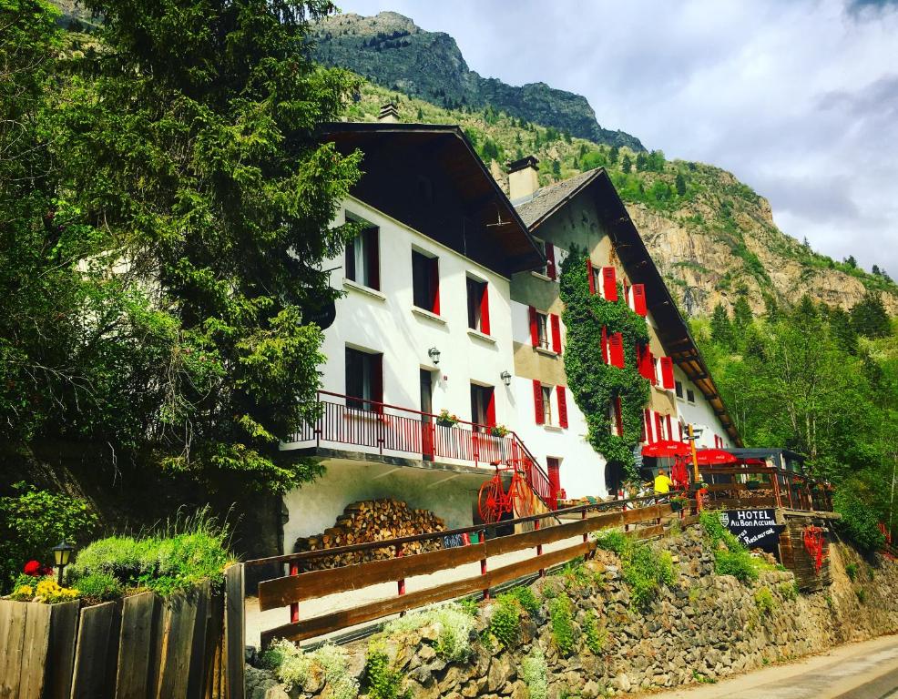 ein weißes Gebäude mit roten Fenstern auf einem Berg in der Unterkunft Hotel Au Bon Accueil in Les Deux Alpes