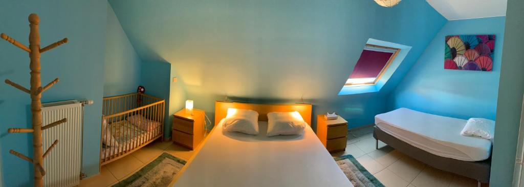 ein kleines Schlafzimmer mit einem Bett und einem Kinderbett in der Unterkunft Villa D'este in De Haan