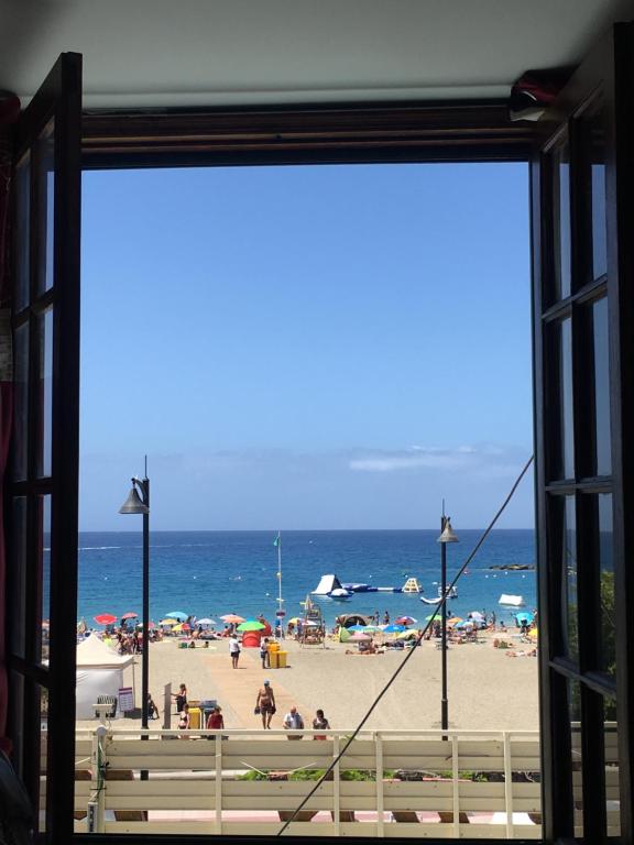 - une vue sur la plage depuis la fenêtre dans l'établissement La Niña - Ocean View Apartment, à Arona