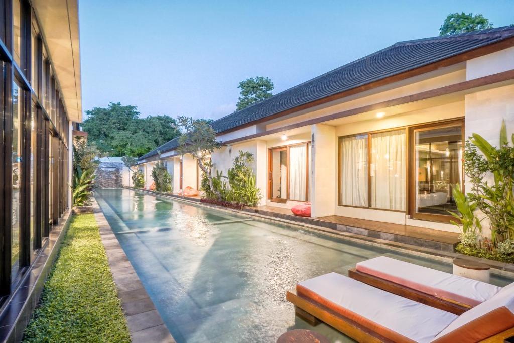 a swimming pool in the middle of a house at Gaing Mas Jimbaran Villas by Gaing Mas Group in Jimbaran