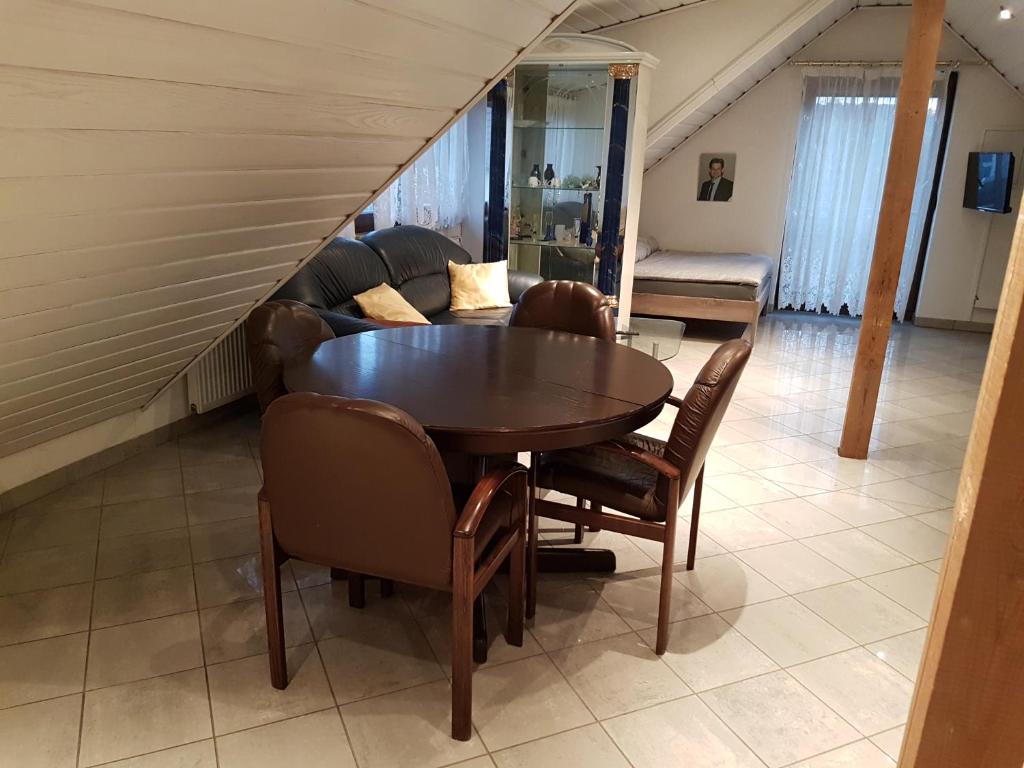 a dining room with a table and chairs and a couch at Gino s Ferienwohnung in Illingen