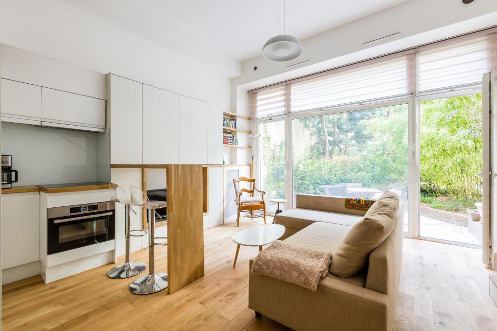 a living room with a couch and a table at Veeve - Natural Heights in the 6th in Paris