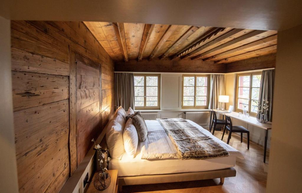 a bedroom with a bed in a room with wooden walls at Hotel Restaurant Falkenburg in St. Gallen