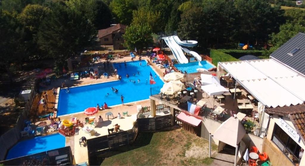 una vista aérea de una gran piscina con gente en ella en Camping LE PIGEONNIER en Saint-Crépin-et-Carlucet