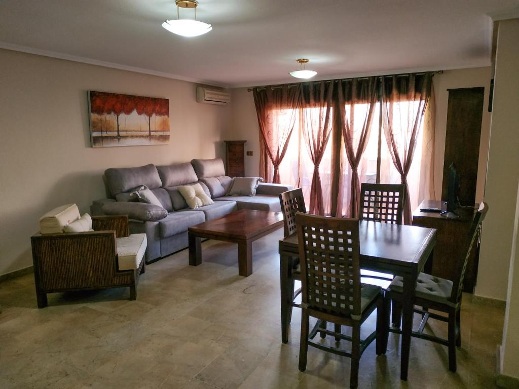a living room with a couch and a table and chairs at Apartamentos Deluxe San Julian in Torrevieja