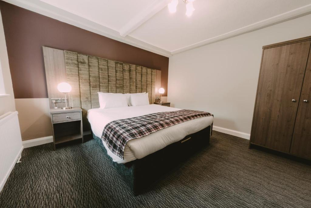 a hotel room with a bed and a desk at Ramada Resort Cwrt Bleddyn Hotel & Spa in Usk
