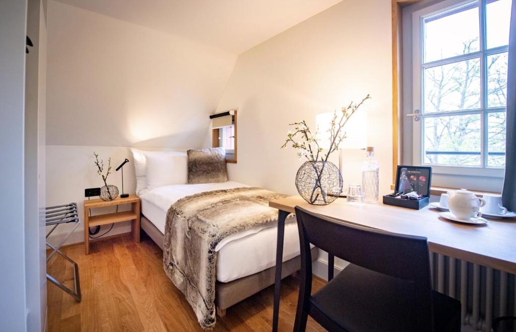 a bedroom with a bed and a desk with a desk at Hotel Restaurant Falkenburg in St. Gallen