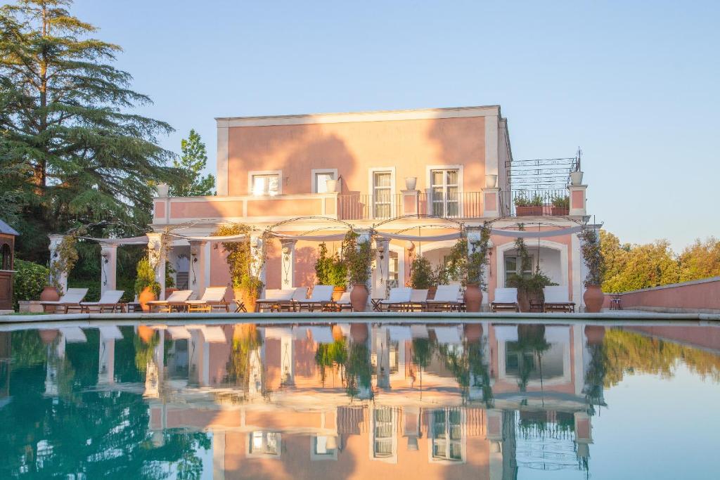 una grande casa con una piscina di fronte di Relais Villa San Martino a Martina Franca