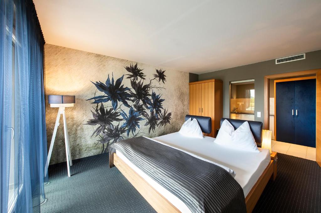 una habitación de hotel con una cama y un cuadro en la pared en ALIA appartements & wellness, en Lagundo