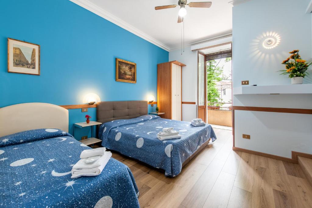 um quarto com 2 camas e paredes azuis em Alessandro A San Pietro Best Bed em Roma