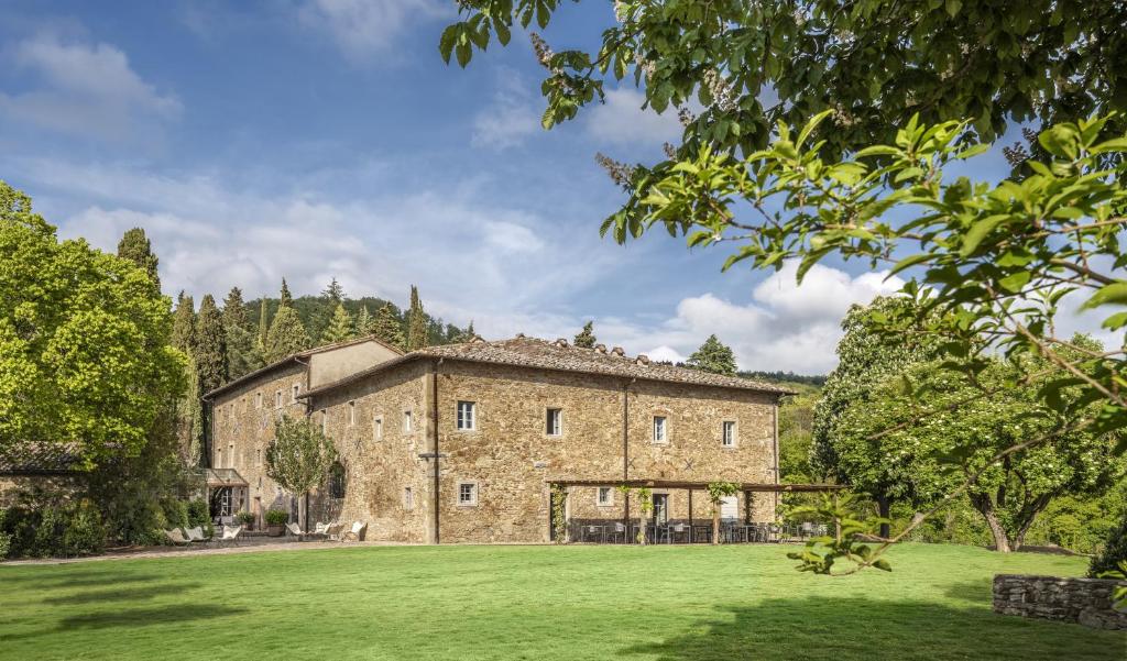eine Außenansicht eines großen Steingebäudes mit einem Hof in der Unterkunft Badia di Pomaio in Arezzo