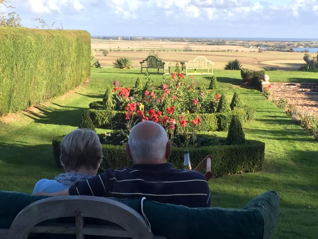 um homem e uma mulher sentados num banco num jardim em Saltcote Place em Rye