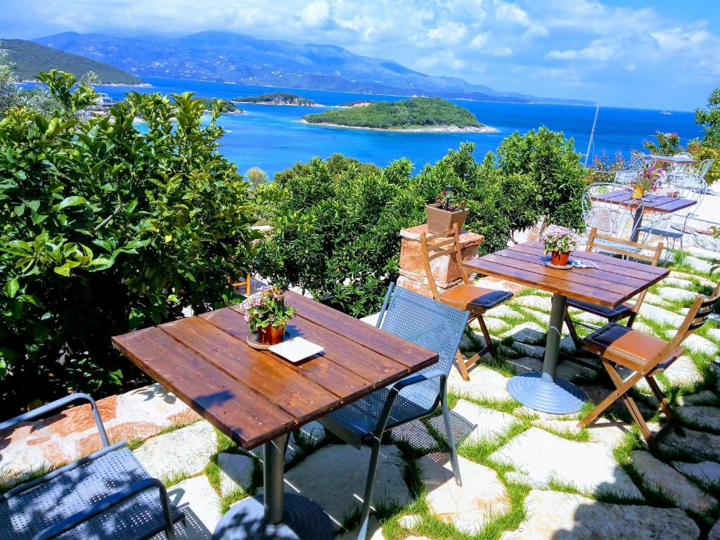 una mesa y sillas en un patio con vistas al océano en John's Guesthouse, en Ksamil
