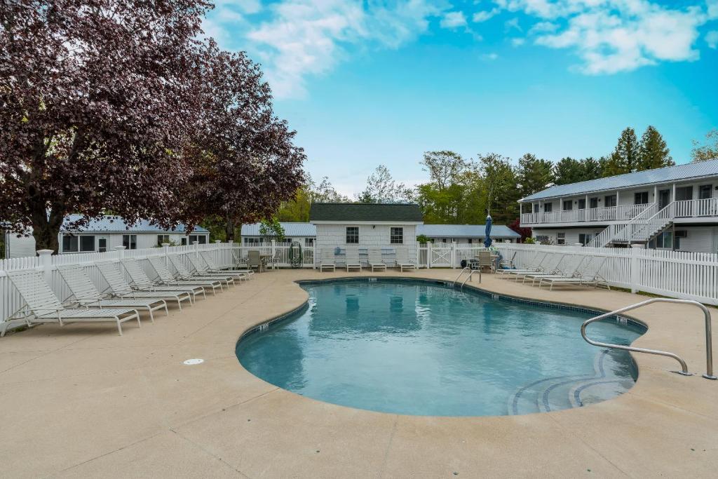 une grande piscine avec des chaises et un bâtiment dans l'établissement Ne'r Beach Motel, à Wells