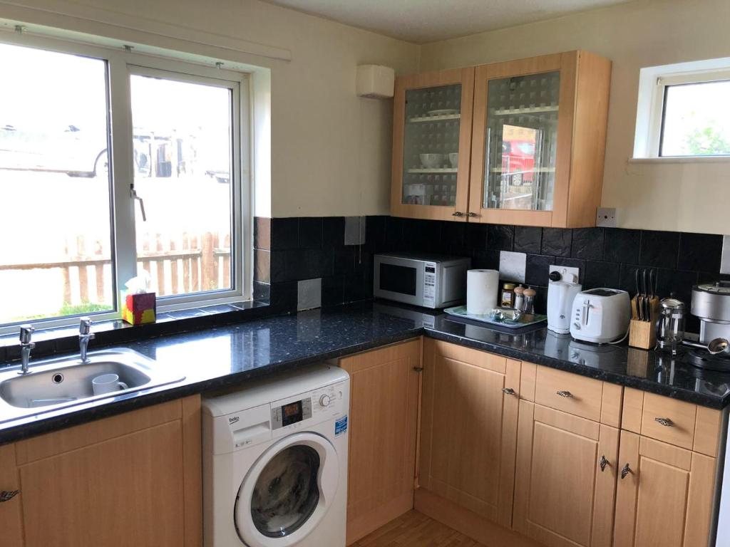 a kitchen with a washing machine and a sink at Florence Court Andover in Andover