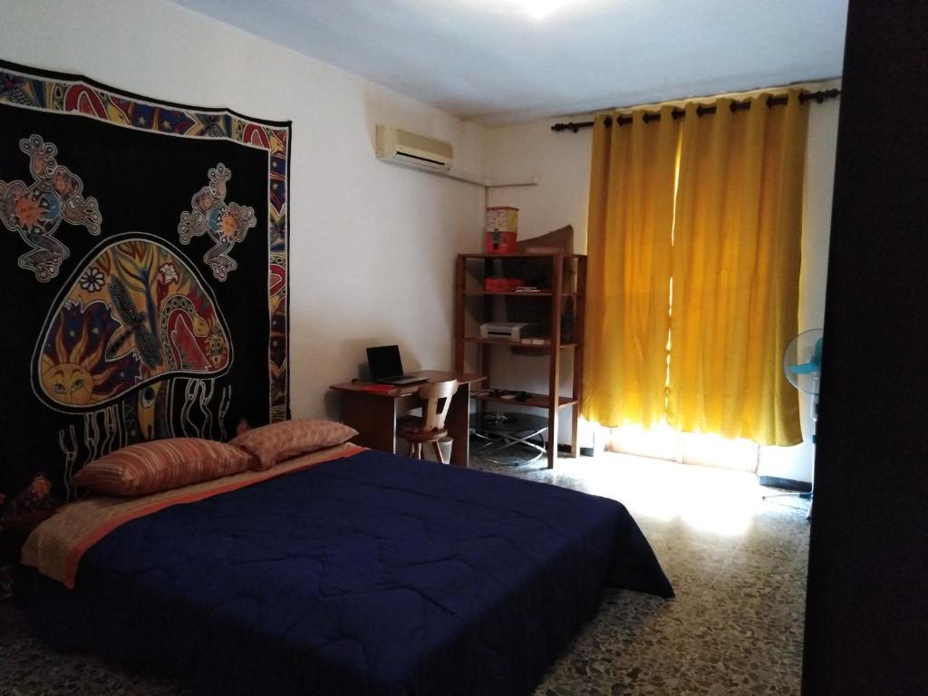 um quarto com uma cama com uma colcha azul em colors house em Alghero