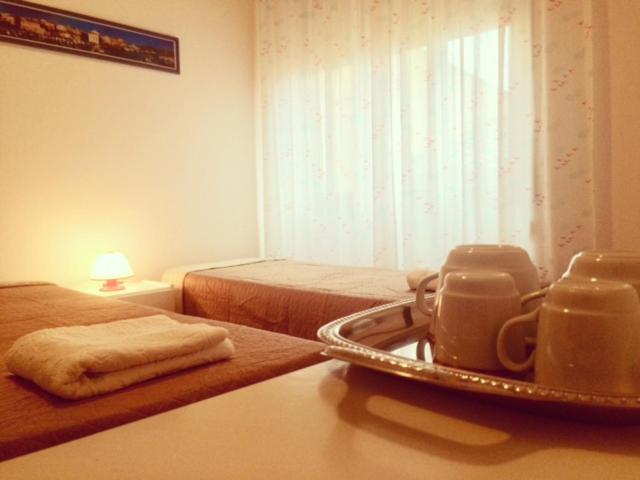 a bedroom with two beds and a table with two cups at A Due Passi in La Maddalena