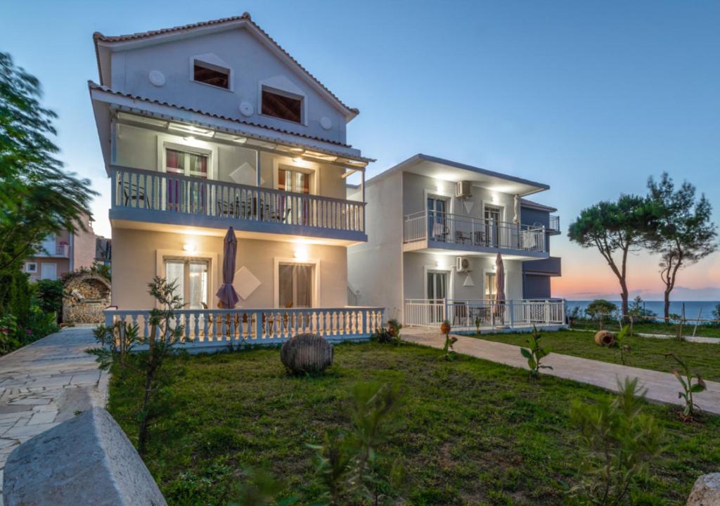 a large white house with a yard in front of it at Villa Antonis deluxe apartments in Amoudi