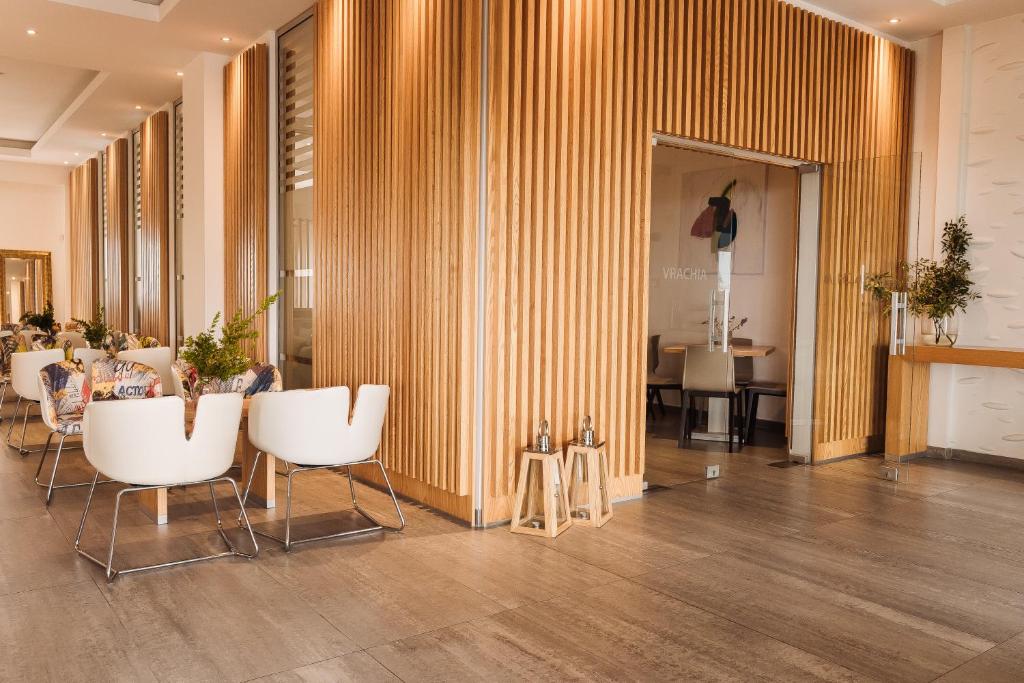 a lobby with white chairs and a table in a room at Vrachia Beach Hotel & Suites - Adults Only in Paphos