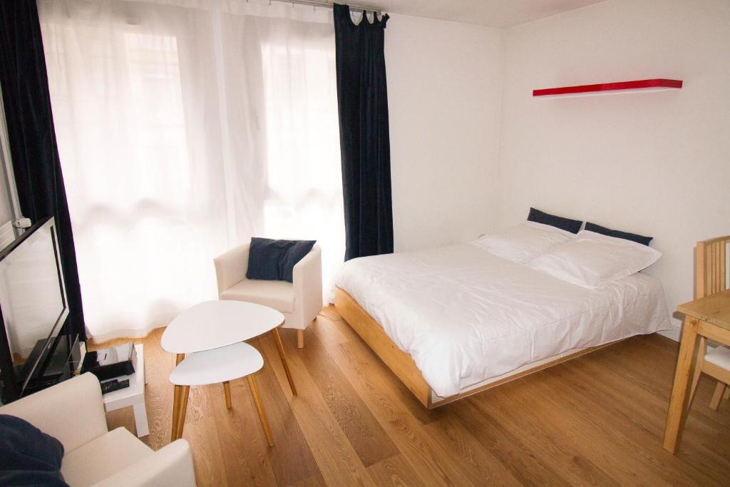 リールにあるStudioLille - Saint Michelのベッドルーム1室(ベッド1台、テーブル、椅子付)