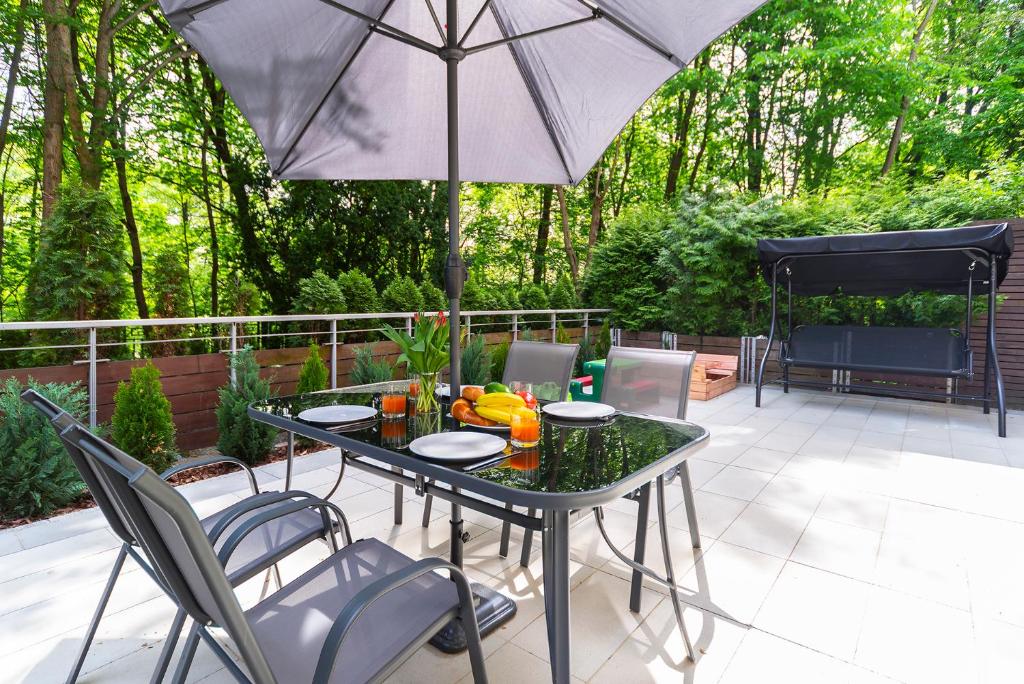 a table with chairs and an umbrella on a patio at Beachfront Apartment Haga with Free Parking by Renters in Sopot